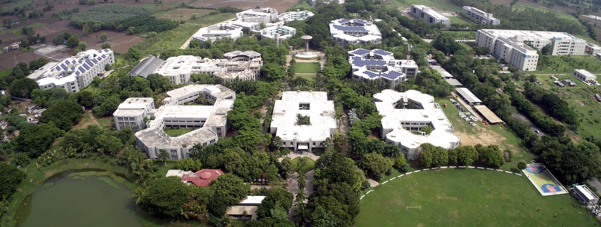 Front of the Charusant University Building with Palm Trees and Students
